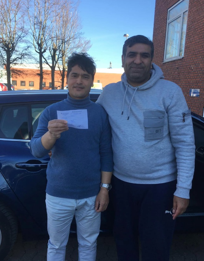 Sheraz med elev ved køreskolebil efter bestået køreprøve